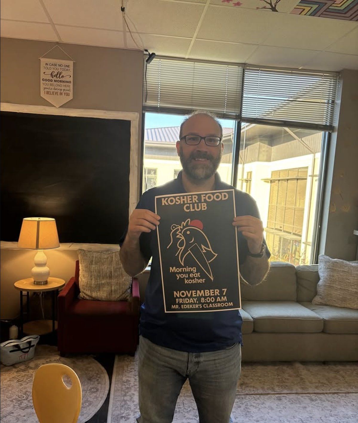 A teacher holding the Morning You Eat Kosher breakfast poster